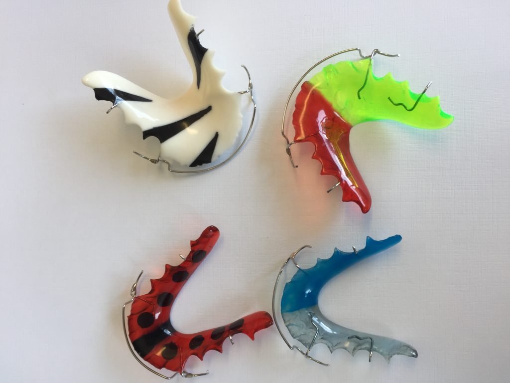 4 different color retainers next to each other.
