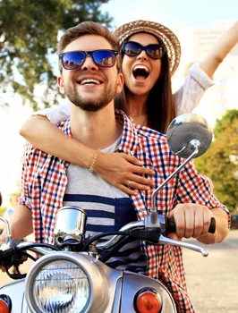 Couple riding motorcycle smiling and laughing with beautiful straight smiles