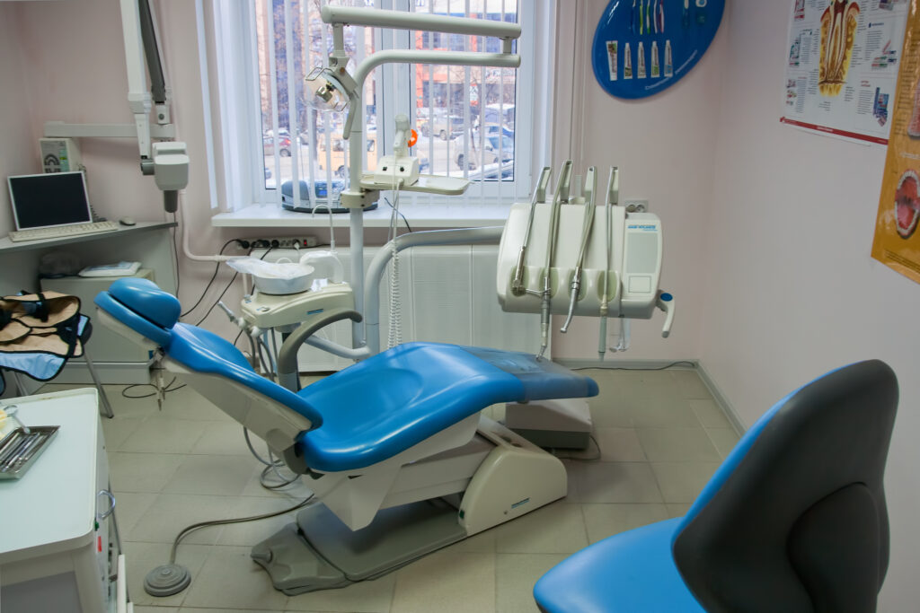 A modern dental office with a blue dental chair and dental equipment.